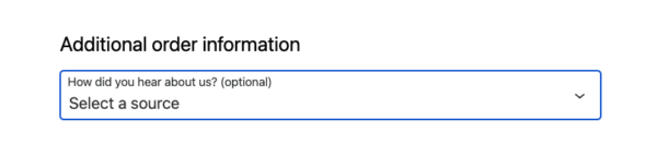 WooCommerce checkout page displaying an additional order information field labeled 'How did you hear about us?' with a dropdown menu showing 'Select a source'.